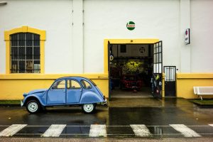 A 2CV parked outside a vintage garage in Pierrefitte-Nestalas, Occitanie, France.